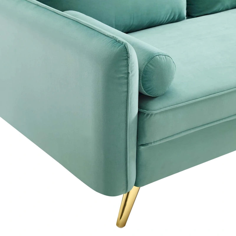 Dwustronna welurowa sofa dwuosobowa ze złotymi nóżkami i poduszkami